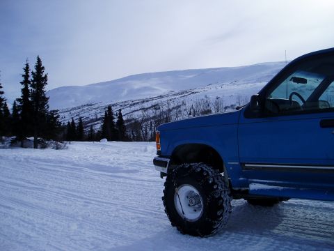 2000 Ford E350 - Pickup truck with snow chains on tires in a winter landscape. Supermotors.net logo is present.