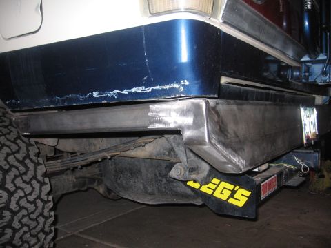 1990 Ford Bronco - Custom rear bumper installed on a vehicle, a JEG'S mud flap and visible suspension components.