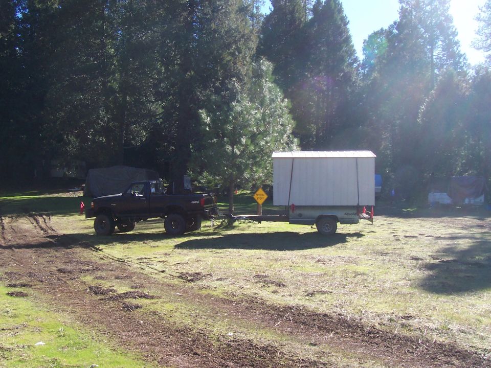 1994 Ford F-150 side view towing a white cargo trailer