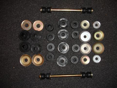 1993 Ford Taurus - A collection of suspension bushings and links are displayed on a dark, textured surface.