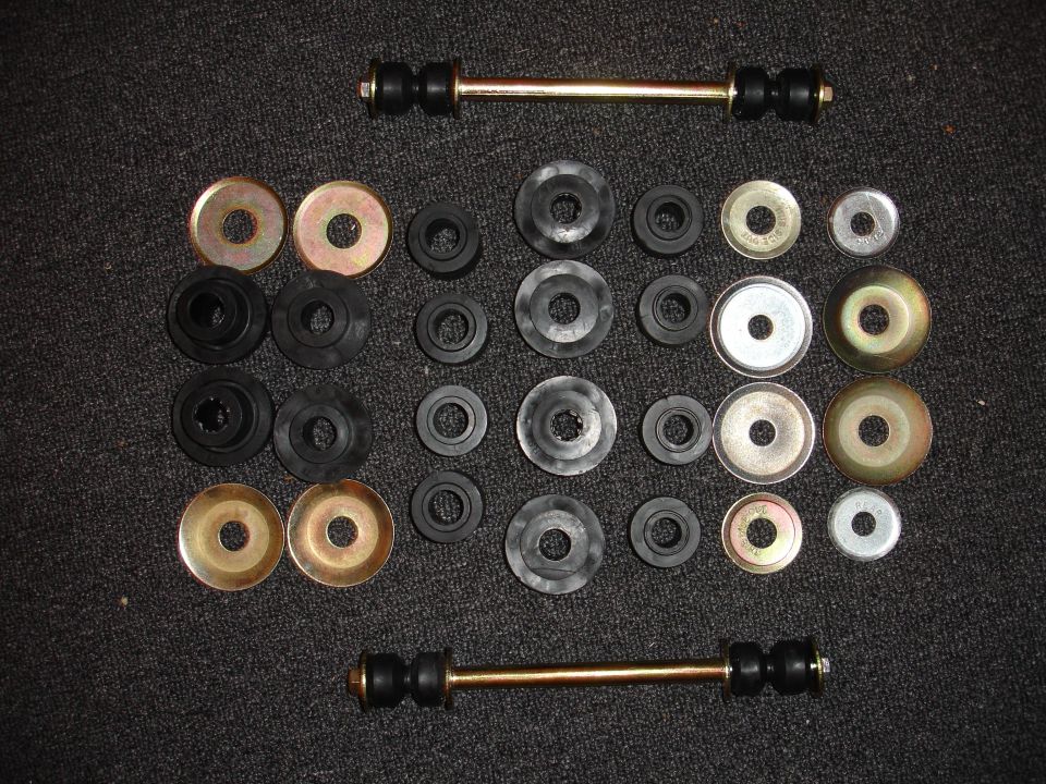 Suspension bushings and links laid out on dark carpet