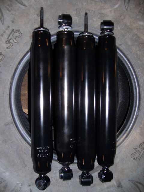 1983 Ford Bronco - Four black shock absorbers are shown, with some text visible on one of them.