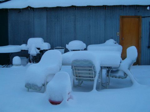 1985 Ford Bronco - Outdoor patio furniture and tables are completely covered in a thick layer of snow.