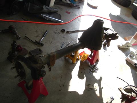 1989 Ford Bronco - A differential axle assembly is shown disassembled on jack stands, surrounded by various tools.
