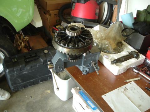 1989 Ford Bronco - A differential gear assembly is secured in a vise, surrounded by tools and parts, suggesting a repair or rebuild process.