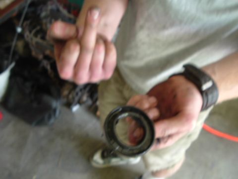 1989 Ford Bronco - A person holds a mechanical part, possibly a seal or bearing, in their hand.