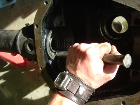 1989 Ford Bronco - A hand works on a differential housing, likely during a regear or rebuild process.