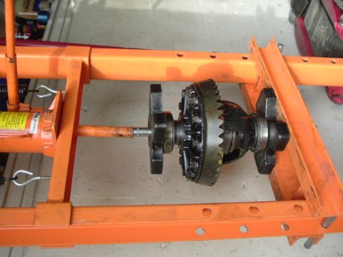 1989 Ford Bronco - Differential assembly on an orange metal stand with a hydraulic jack.