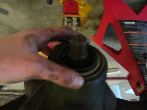 1989 Ford Bronco - A hand grips a differential part, likely during a regear or rebuild process, with a jack stand visible in the background.