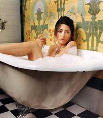 1991 Ford Bronco - A woman enjoys a relaxing bath with bubbles and a drink in a vintage-style bathroom.