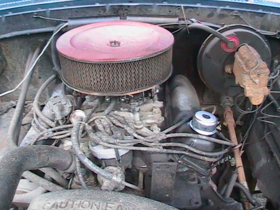 Engine bay showing carburetor, air cleaner, distributor, and brake booster