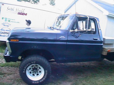 1977 Ford F-250 - A dark blue 1977 Ford F-250 pickup truck is parked outdoors next to a trailer.