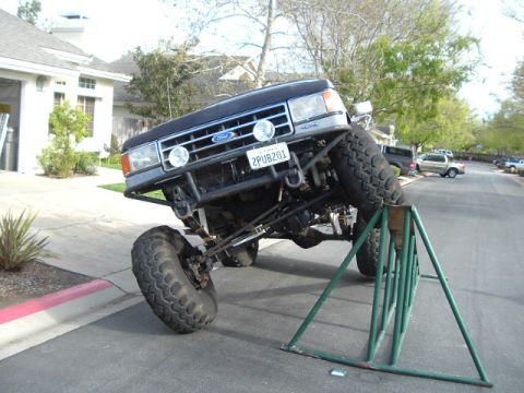 1989 Ford Bronco - This modified Ford Bronco is positioned on a ramp, its lifted suspension and off-road capabilities.