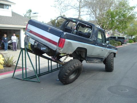 1989 Ford Bronco - This modified Ford Bronco is propped up on green ramps, its lifted suspension and large off-road tires.