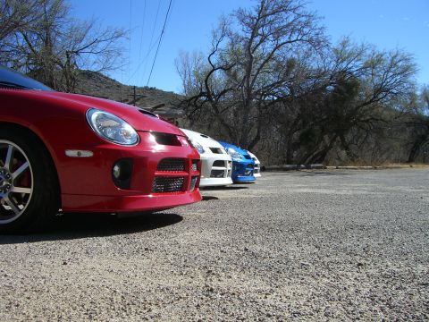 1996 Ford Probe - A line of Dodge Neon SRT-4s are parked in a gravel lot under a clear blue sky.