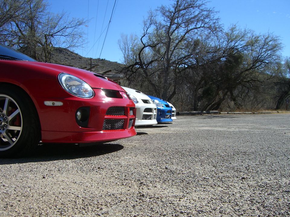 Red Dodge Neon SRT-4 in a line of cars, front view