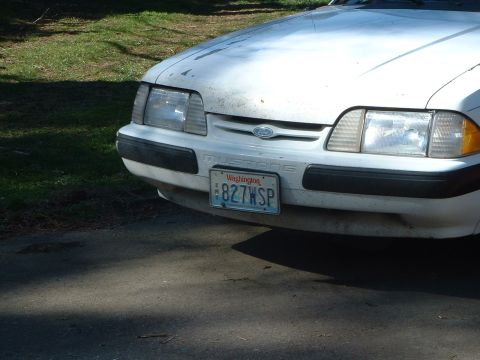 1987 Ford Mustang - The front of a white Ford Mustang is shown, a Washington license plate.
