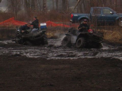 1987 Suzuki Samurai - ATVs navigating a muddy terrain, with a pickup truck visible in the background.