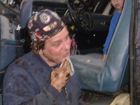 1987 Suzuki Samurai - A person is cleaning their face while inside a vehicle, with a child visible in the background.