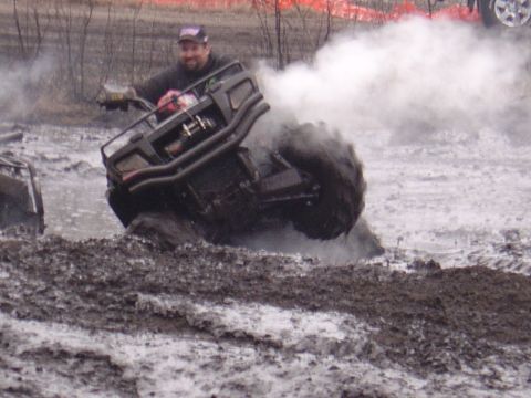 1987 Suzuki Samurai - An ATV is stuck in the mud, creating a large cloud of smoke and spray.