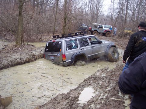 1974 Ford Bronco - Off-roading Jeeps navigate a challenging muddy trail.