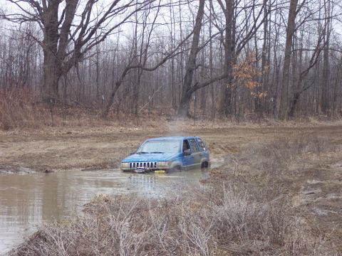 1974 Ford Bronco - Jeep Grand Cherokee stuck in mud, off-roading scene.