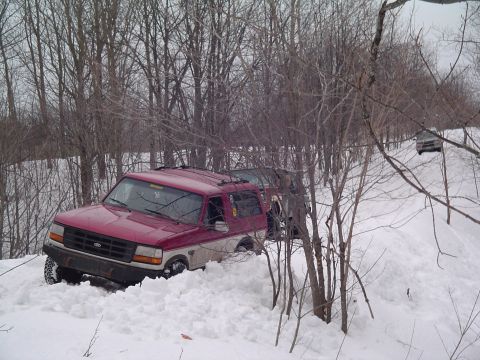 1994 Ford Bronco - Two vehicles navigate a snow-covered path with one Ford Bronco deeply stuck in the snow.