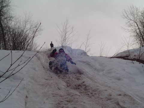 1994 Ford Bronco - Winter fun on a snowy slope with a person sledding downhill.