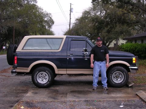 1988 Ford Bronco - Man poses with his 1988 Ford Bronco, showing off the two-tone paint and spare tire.