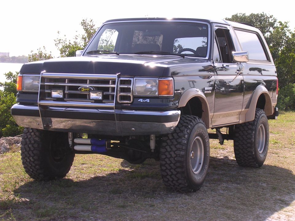 Lifted black Ford Bronco with off-road tires and a chrome grille guard