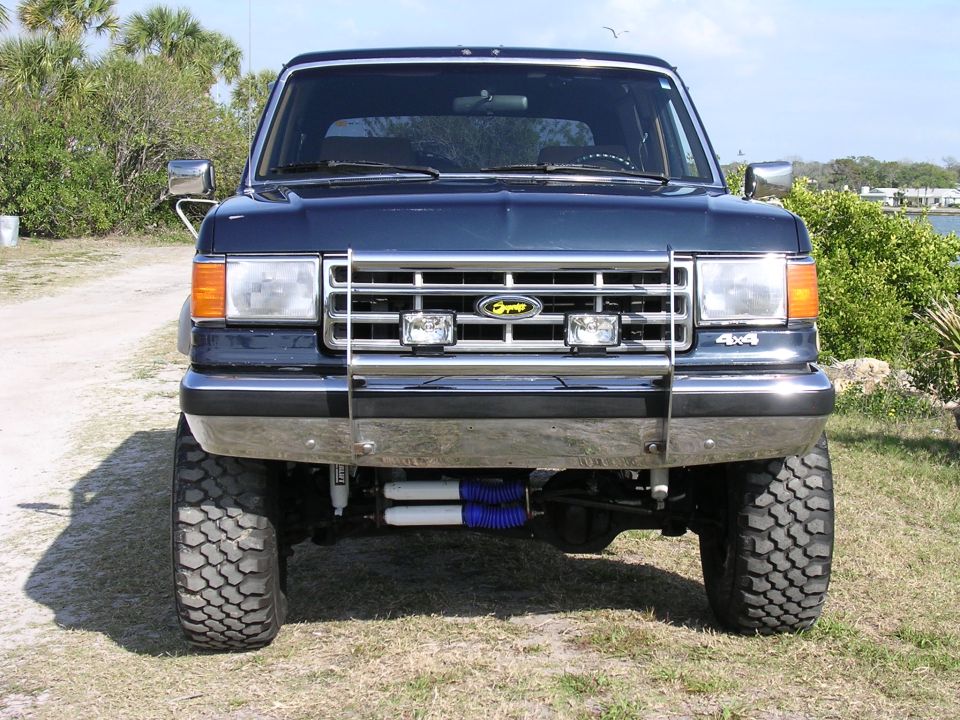 Dark blue lifted Ford Bronco front view with chrome grille and bumper