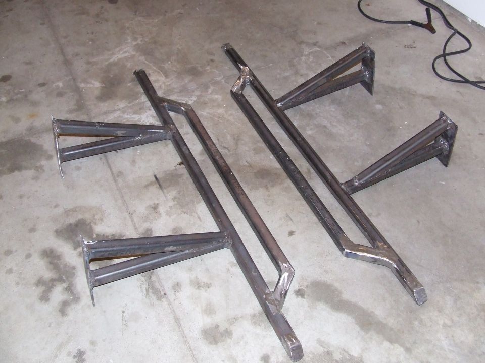 Two custom steel rock sliders on a concrete floor