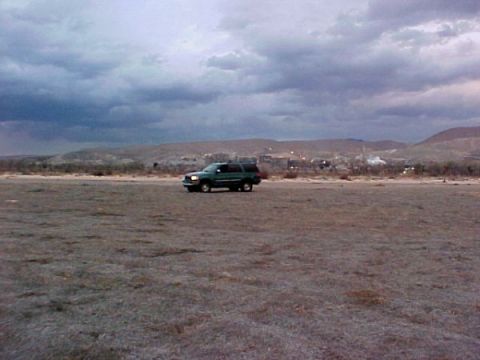 1997 Ford Expedition - A 1997 Ford Expedition is seen driving across a barren landscape with hills in the background under a dramatic, cloudy sky.