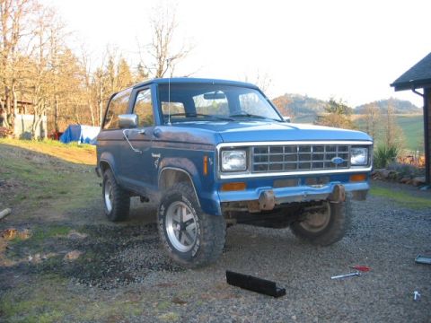 1991 Ford Explorer - A blue 1989 Ford Bronco II is parked outside on a gravel driveway.