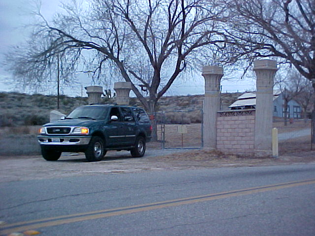 1997 Ford Expedition parked on dirt road near gate with stone pillars