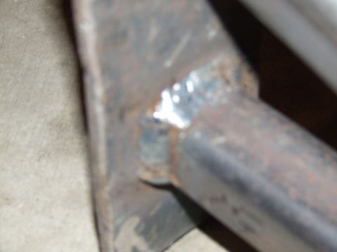 1986 Ford Bronco - A close-up view of a welded metal rock slider, showing signs of rust and a watermark from Supermotors.net.