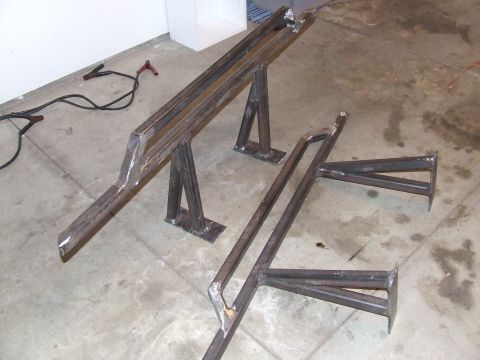 1986 Ford Bronco - Welding cables and two metal fabrication stands are shown on a concrete floor.
