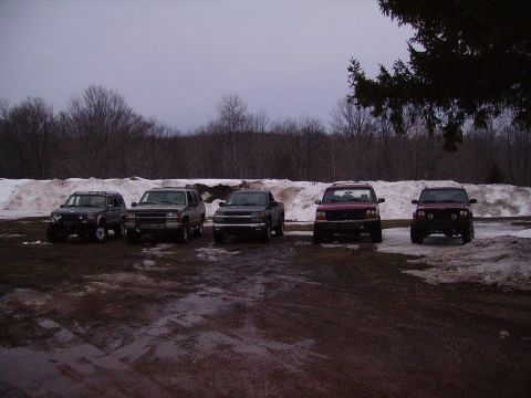 2000 Chevrolet Tahoe - A collection of SUVs and trucks are parked in an outdoor lot during a cloudy day.