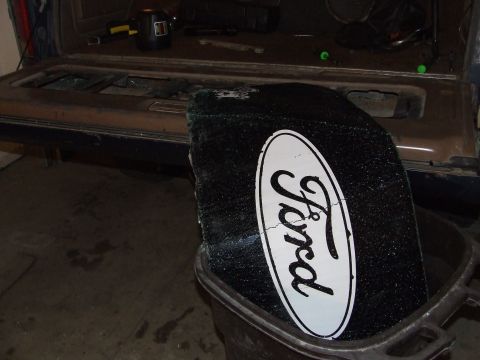 1986 Ford Bronco - Ford logo on broken glass, likely from a vehicle's rear window.