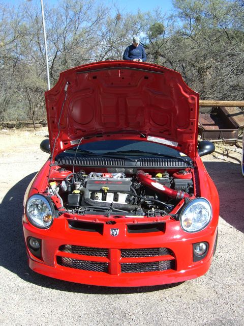 1996 Ford Probe - The front of a red Dodge Neon SRT-4 is shown with its hood open, revealing the engine compartment.