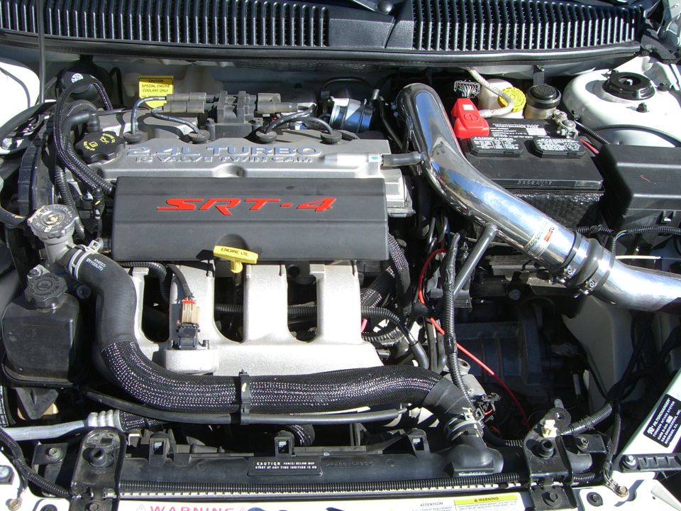 Engine bay with SRT-4 turbo engine, intake piping, and battery