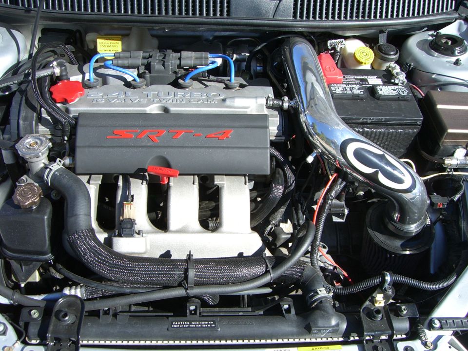 Engine bay with SRT-4 branding on the valve cover and a chrome intake pipe