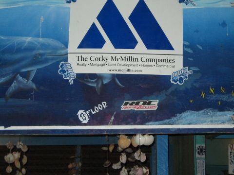 1990 Ford Bronco - Corky McMillin Companies banner hangs over a storefront painted with an underwater dolphin mural.