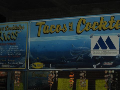 1990 Ford Bronco - blue Tacos y Cocteles seafood stand sign features a painted shark and stickers including Corky McMillin.