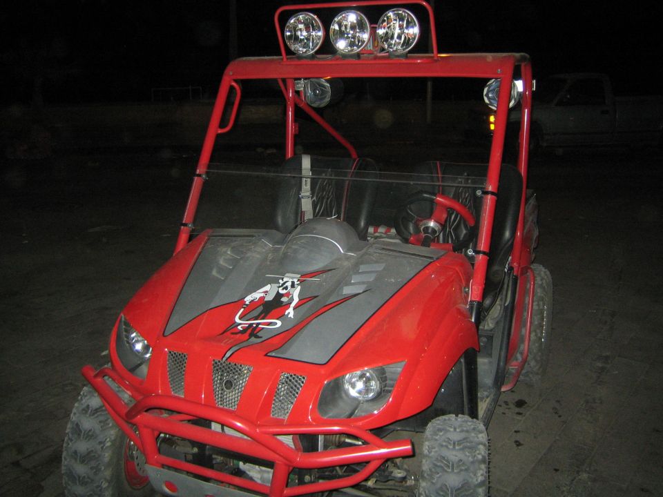 Red Yamaha side-by-side UTV with roll cage and light bar at night