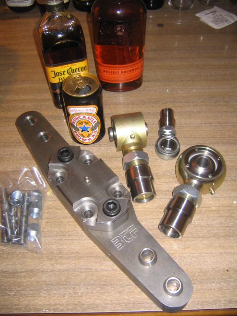 1978 Ford Bronco - Several metal automotive parts are laid out on a wooden surface alongside alcoholic beverages.
