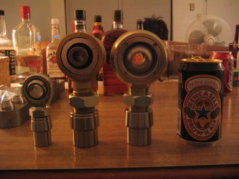 1978 Ford Bronco - Close-up of automotive rod ends and a beer can on a table, with bottles in the background.