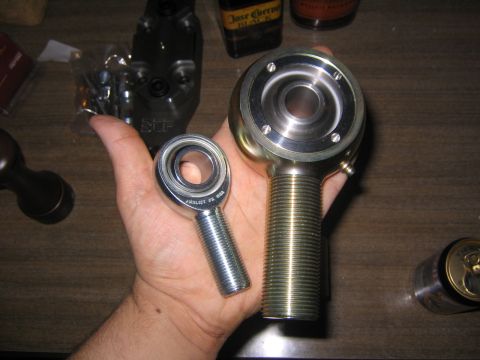 1978 Ford Bronco - A hand displays two rod ends of different sizes, with a can and bottles in the background.