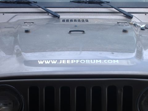 2004 Jeep Wrangler - Front view of a gray Jeep Wrangler, a WWW.JEEPFORUM.COM sticker on the hood and its signature grille.