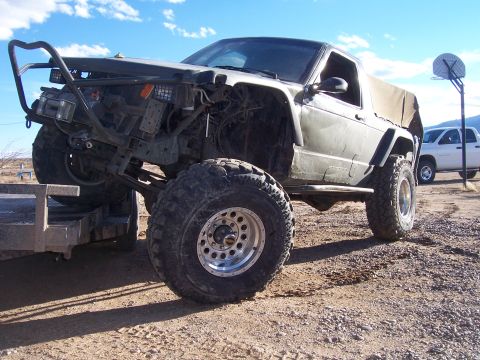 1981 Ford F-150 - Modified SUV with custom front bumper and large off-road tires is loaded onto a trailer.